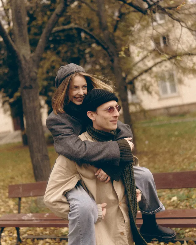 Elvira on Sergei's back, both laughing, autumn park