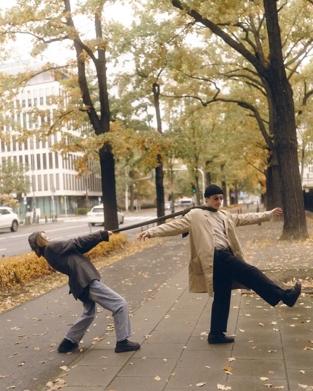 Both leaning sideways on a city pavement, mirroring each other