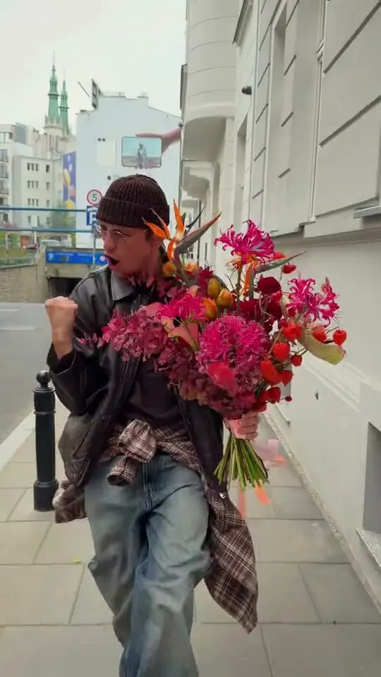 Sergei with a huge pink bouquet, walking down a street