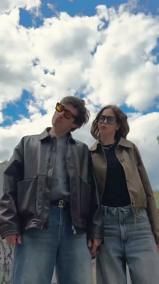 Sergei and Elvira running toward the camera along a graffiti wall